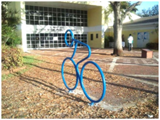 Bike rack in the shape of a stick person riding a bike